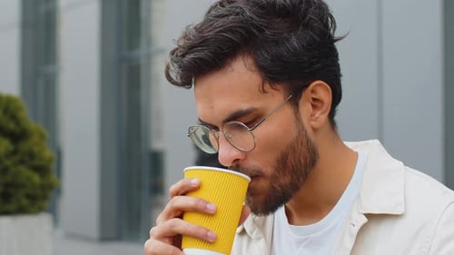 Happy Indian Man Enjoying Drinking Morning Coffee Hot Drink Relaxing Taking a Break in City Street