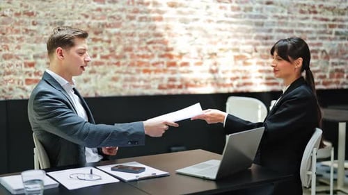 Business Meeting Businessman and Businesswoman Discussing a Contract in Modern Office