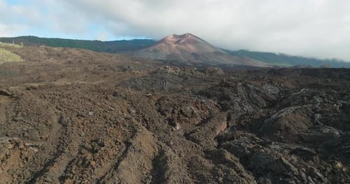 Rugged volcanic lava field with aerial view of Tajogaite volcano
