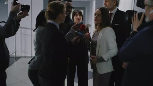 Journalists Interview Woman in Hallway During Press Conference