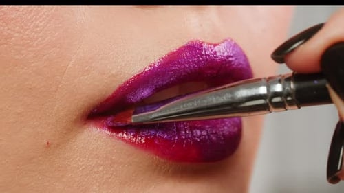 Junge Frau, Make-up mit rotem Lippenstift mit lila Farbe auf ihren Lippen, Nahaufnahme einer Frau