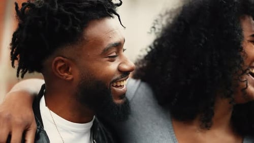 Young Happy African American couple smiling and laughing together, woman with arm around boyfriends