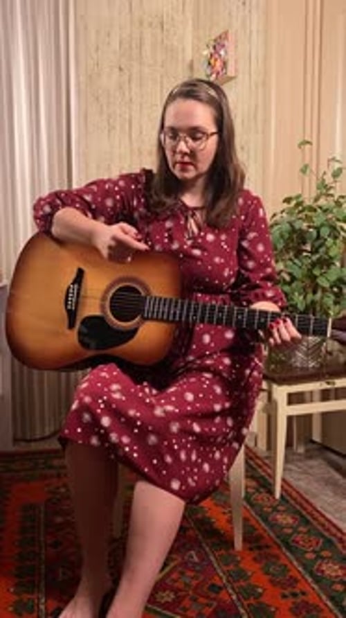 Woman Plays Guitar in Living Room