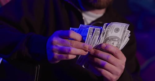 Man Counting Stack of United States Currency Dollars