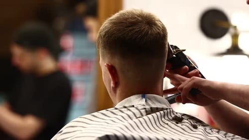 Men's haircut electric razor. Close up hair trimmer hairstyle. Professional hairdresser cutting hair