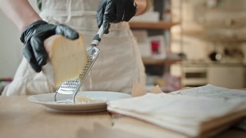 Hands in Black Gloves Grate Block of Cheese in Kitchen Female Hands in Black Gloves Grate Block of