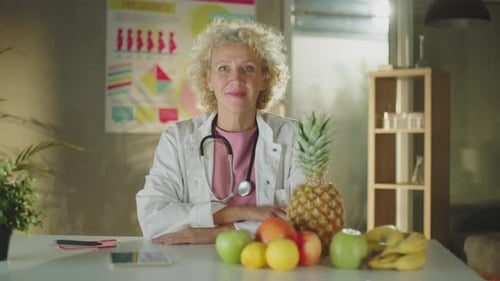 Nutriotionist sitting with fruits on the desk