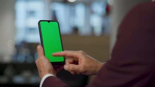User Swiping Green Screen Cellphone At Lobby Closeup. Hand Touching Smartphone. Unrecognized Man ...