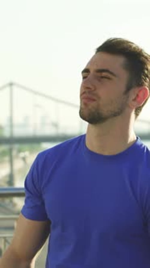 Young Man Stretching Arms and Shoulders Outdoors