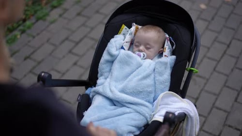 Baby Sleeps Peacefully in Stroller on Brick Path