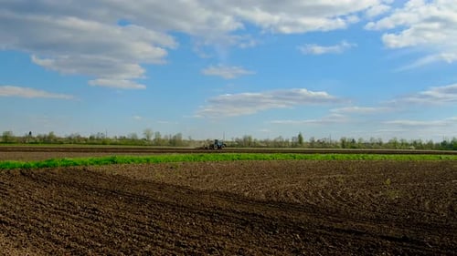 Der Traktor auf dem Feld bearbeitet den Boden