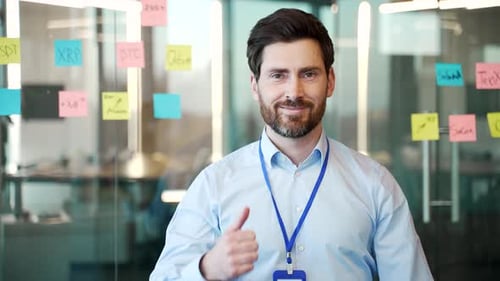 Enthusiastic Businessman Gives Thumbs Up in Modern Office