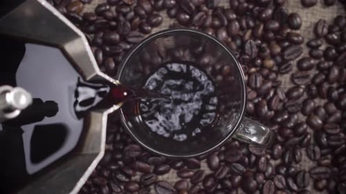 Coffee Poured into Mug on Bed of Beans