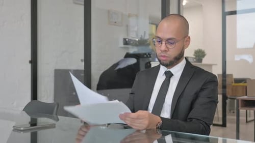 Adult Man Reads Documents in Modern Office