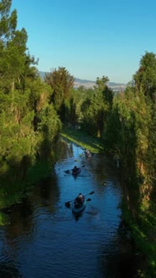 Drone shot of kayakers in canals of of Lake Xochimilco, golden hour in Mexico