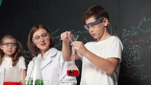 Children and Adult Doing Science Experiment in Classroom