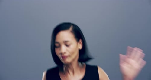 Woman Dances and Smiles on Grey Background