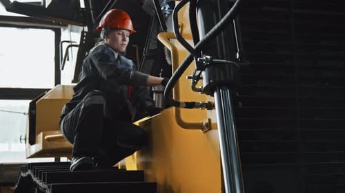 Female Mechanic Engineer Repairing Tractor