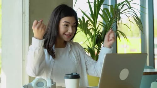 Woman Working on Laptop in Urban Cafe
