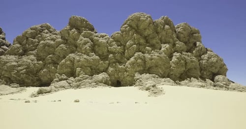 Large Rock Formation in a Desert Landscape Under Clear Blue Sky