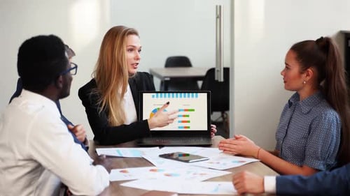 Diverse Colleagues Presenting Business Data in Modern Office