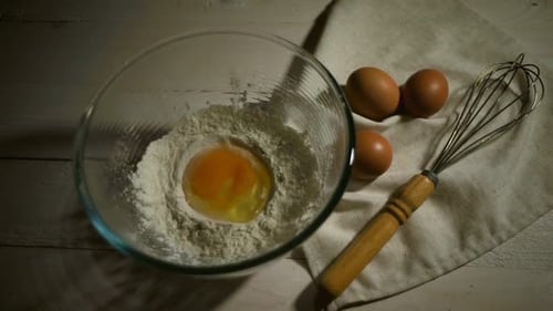 Cracking Egg Into Flour Bowl for Baking
