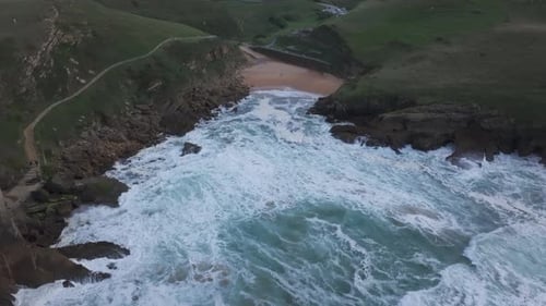 Forward drone view over Santa Justa beach and cliffs in Cantabria