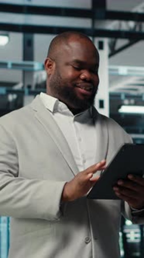 Vertical Video Server Room Worker Troubleshooting Server Connectivity Issues Using Tablet
