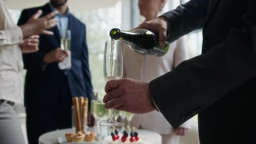 Unrecognizable Man Pouring Sparkling Wine into Glass at Party