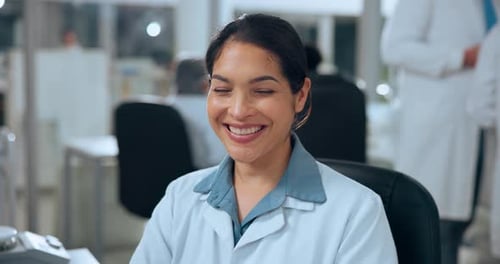 Smiling Woman in Lab Coat at Workplace