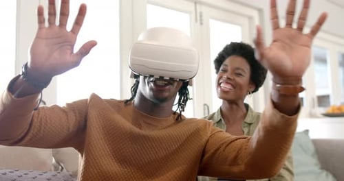 Man Experiences VR with Friend in Bright Home