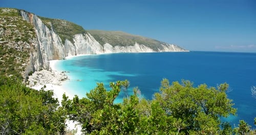 Beautiful Fteri beach on Keflaonia Island, Greece. White rocks and blue lagoon surrounded by green f