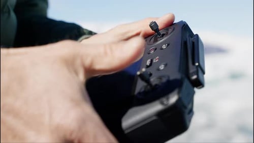 Holding a Drone Remote Control Outdoors in Sunlight
