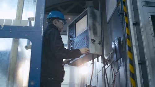 Ein Arbeiter der Schwerindustrie benutzt einen Bedienfeldcomputer in einer Fabrik.