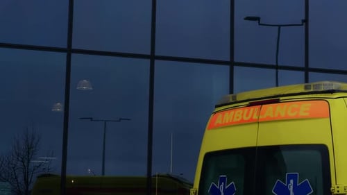 A Yellow Vehicle with Automotive Lighting is Parked in Front of a Building