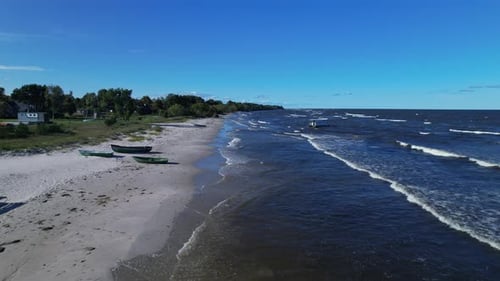 A beach with boats on the water and a sandy shore