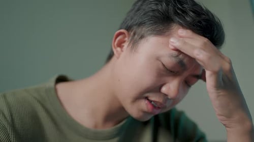 Man with a Headache Touching Forehead