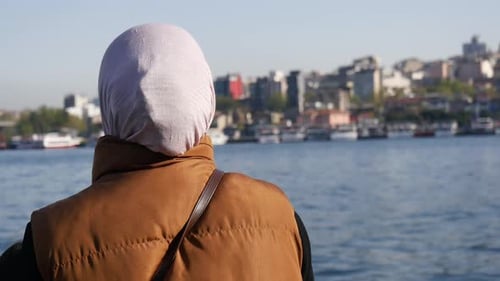 Woman Gazes at Cityscape By the Water in Istanbul