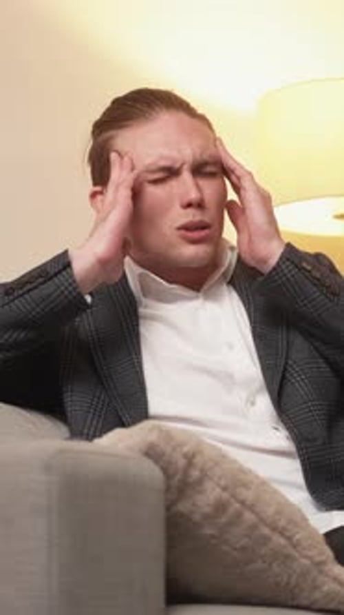 Man With Headache Lying on Couch