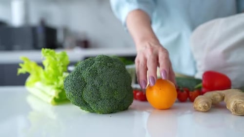 En una cocina contemporánea, una mujer descarga alimentos frescos con bolsas ecológicas