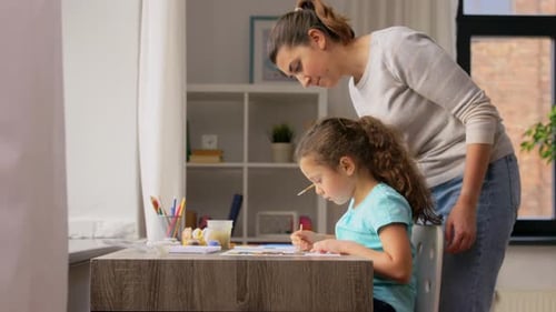 Mother and Daughter Drawing Together at Table Indoors