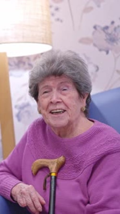Senior Woman Smiling with Cane in Home Setting