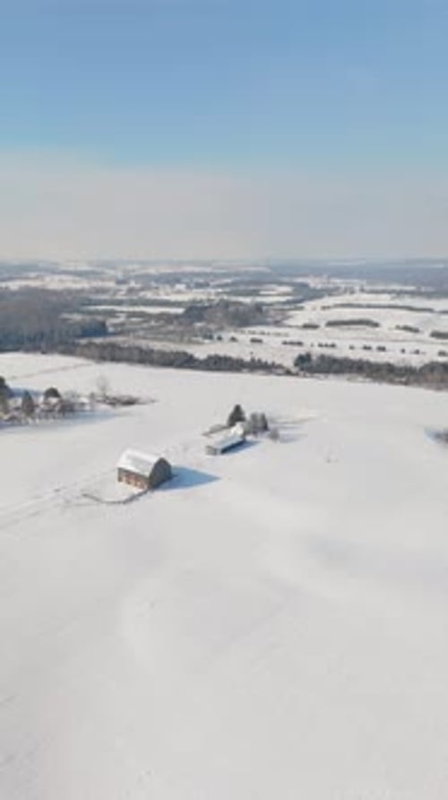 Barn And Farm In A Snow Covered Winter Landscape In Caledon, Canada. Rising Drone Vertical Shot.