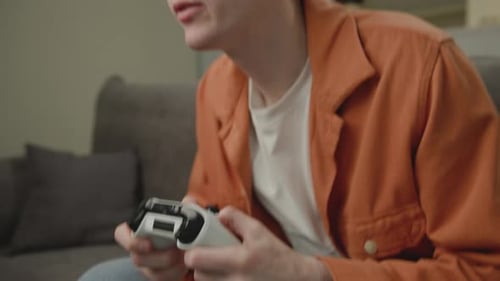 Excited Young Adult Plays Video Game at Home