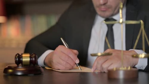 Close up of Judge Writing Legal Verdice in Court
