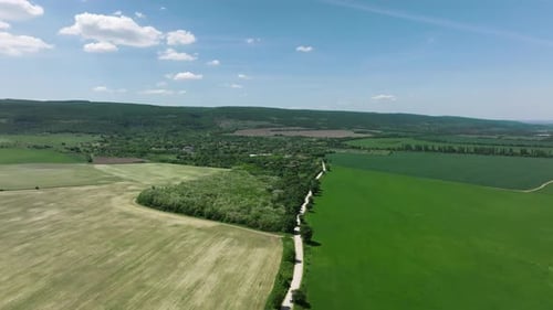 Autofahren auf einer Landstraße, die üppige grüne Felder und Ackerland trennt — Luftaufnahme