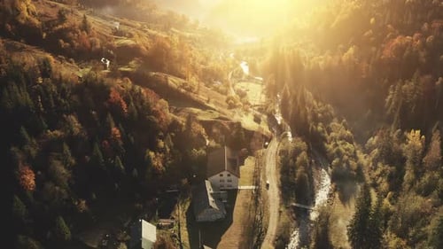 Top Down Slow Motion of Mountain Village Aerial Autumn Nature Landscape at Sunset Cottages at Road