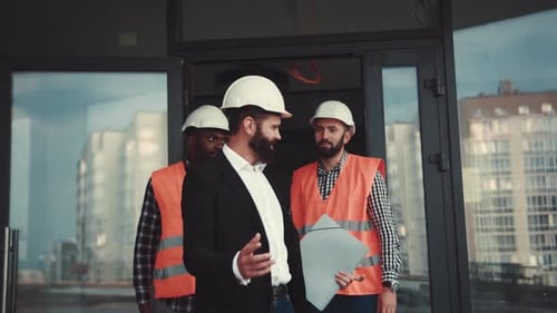 Multiracial Team of Construction Managers Walking Out of the Office Actively Discussing the Project