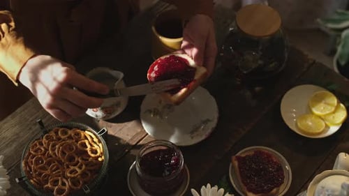 Café da manhã rústico com mãos femininas preparando sanduíche com geléia de frutas vermelhas