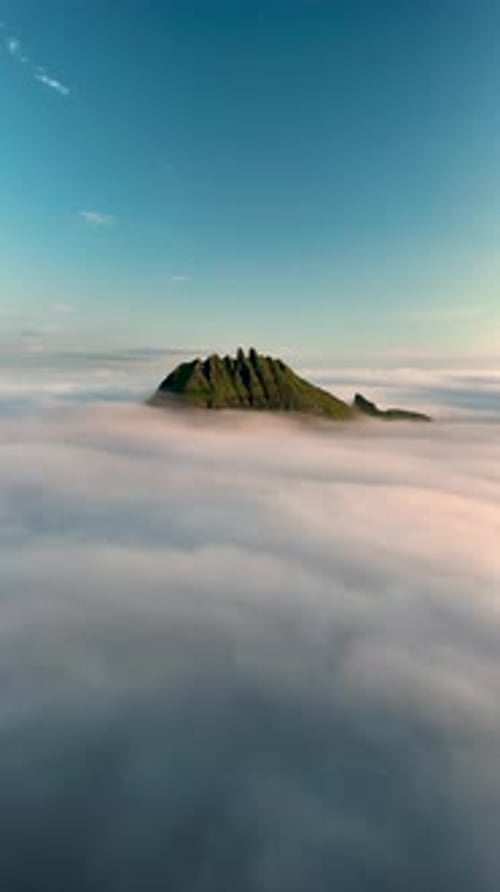 Majestueux Drangarnir s'élevant au-dessus des nuages dans les îles Féroé au lever du soleil